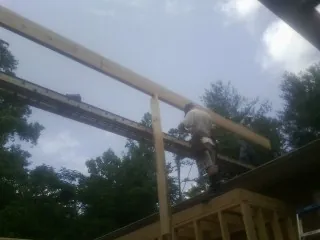 Carpenter setting a ridge beam over a new addition frame — Ice Dam Removal by Roofing Brothers in Pound Ridge