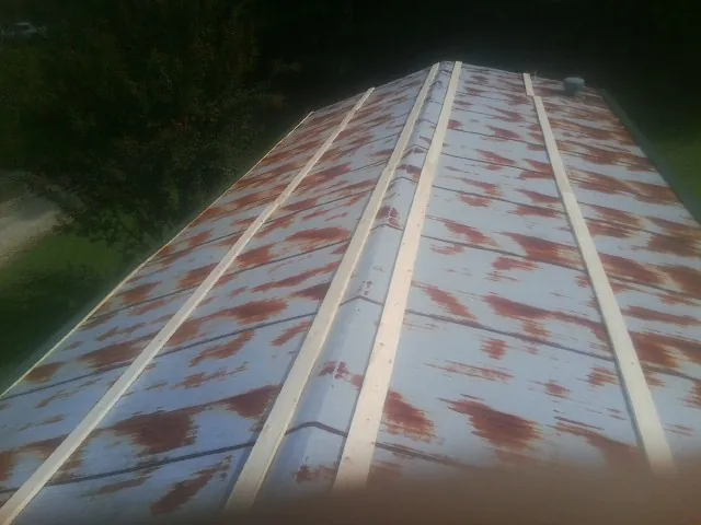 Rusted metal roof panels with new wood purlins before replacement — Storm Damage Roof Repair in Pound Ridge by Roofing Brothers