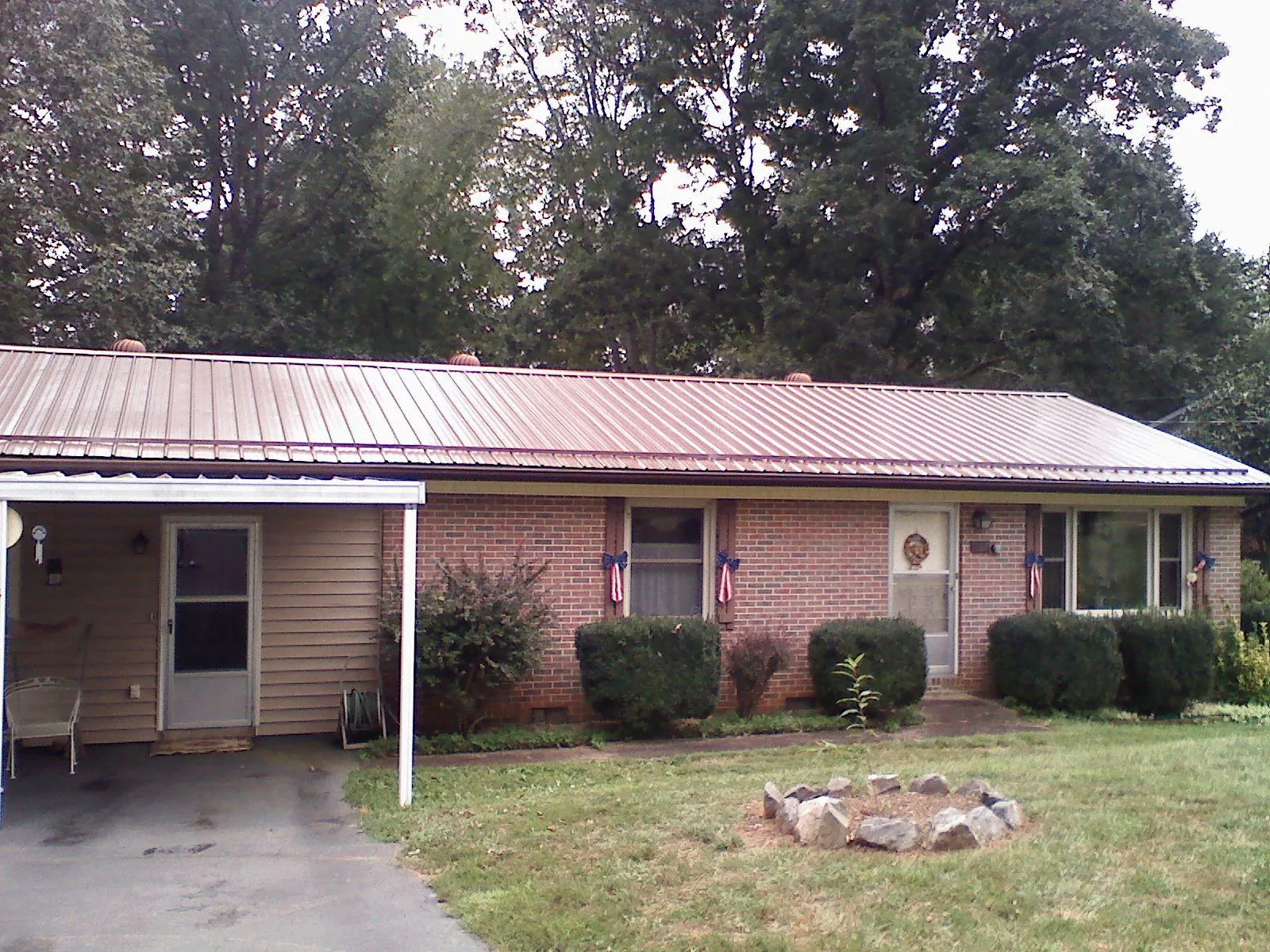 Bronze metal roof and carport on a brick ranch home — Roof Repair work by our crew in Pound Ridge
